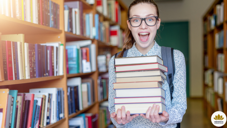 Student in library holding a stack of physical textbooks representing digital sobriety by Abhidnya Learning Spaces